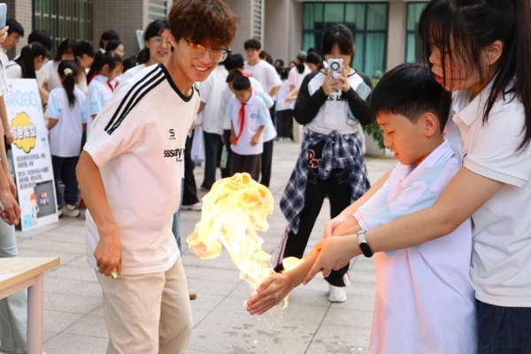 小朋友們在室外廣場體驗“火焰掌”實驗。重慶師范大學供圖 小朋友們在室外廣場體驗“火焰掌”實驗。重慶師范大學供圖